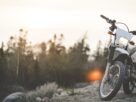 Motorcycles under $8,000 guide: a motorbike parked on a gravel trail with a sunset in the background