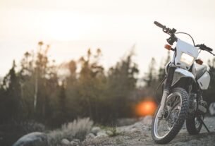 Motorcycles under $8,000 guide: a motorbike parked on a gravel trail with a sunset in the background